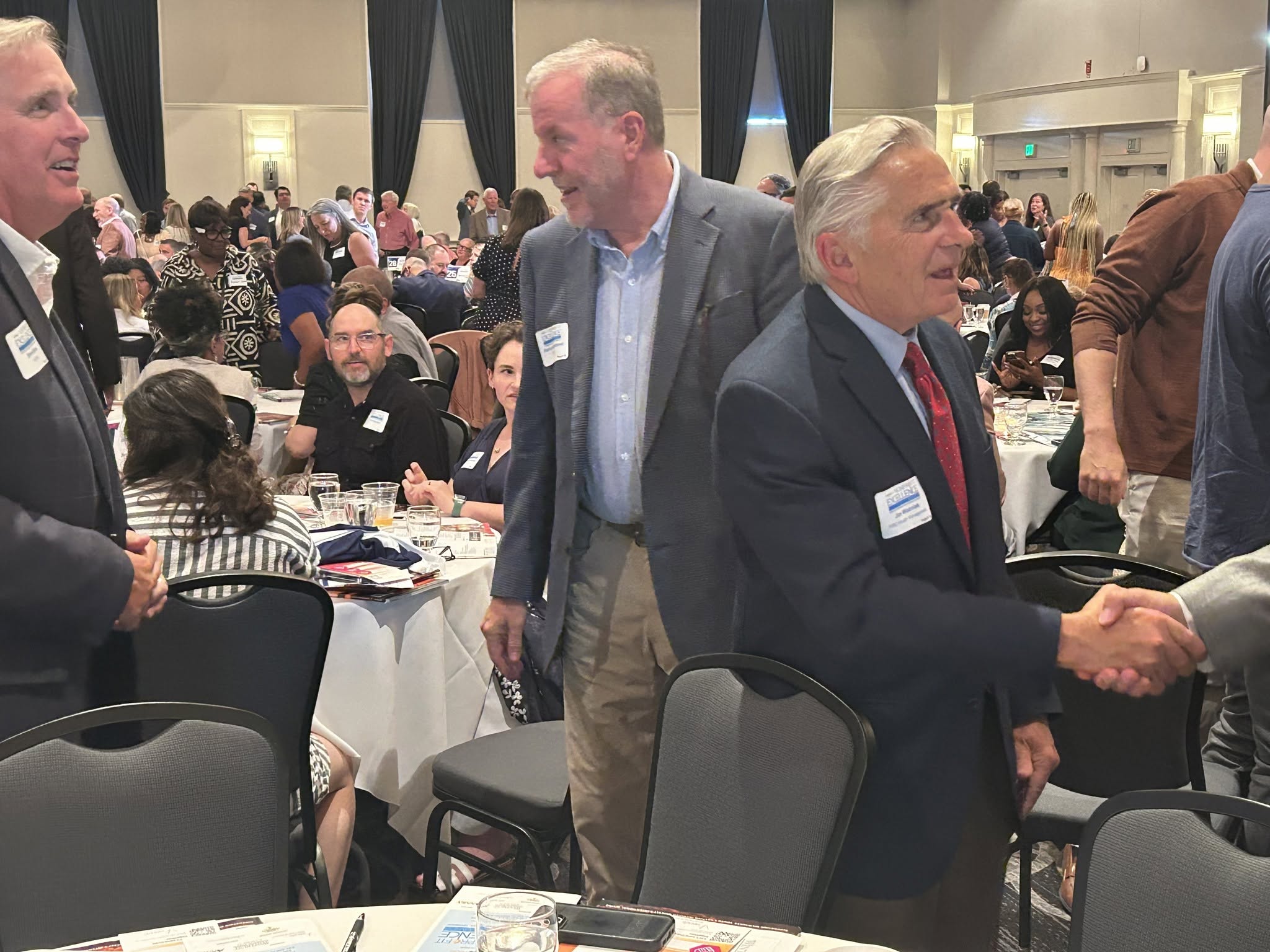 Jim Wozniak greeting fellow attendees at the BizTimes event